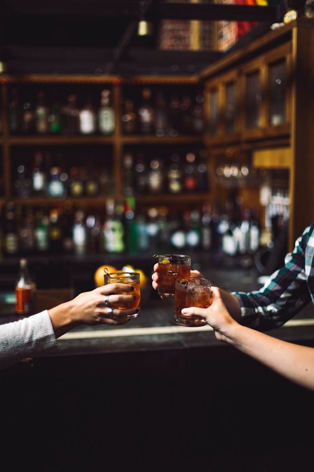 Menschen stoßen in einer Bar mit Getränken an