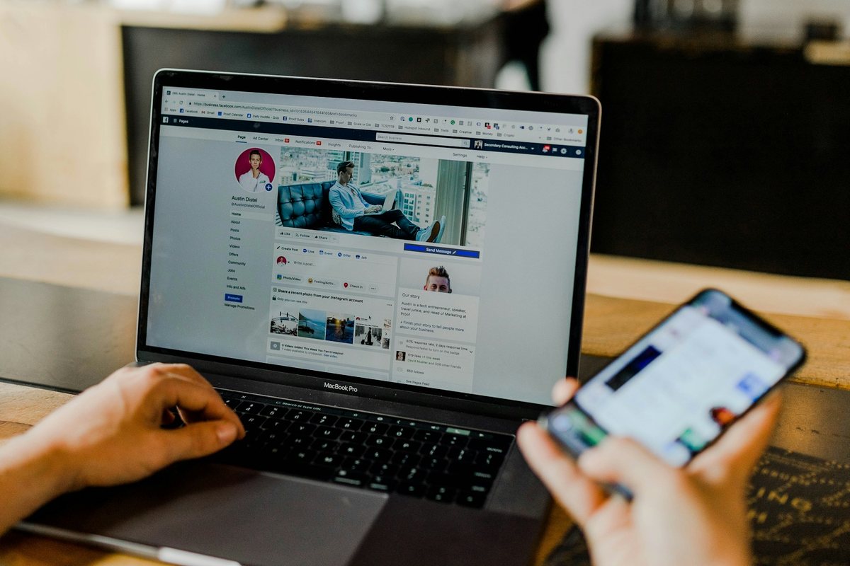 Laptop mit geöffneter Facebook-Seite neben einem Smartphone