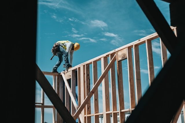 Handwerker arbeitet an einem hölzernen Gebäuderahmen