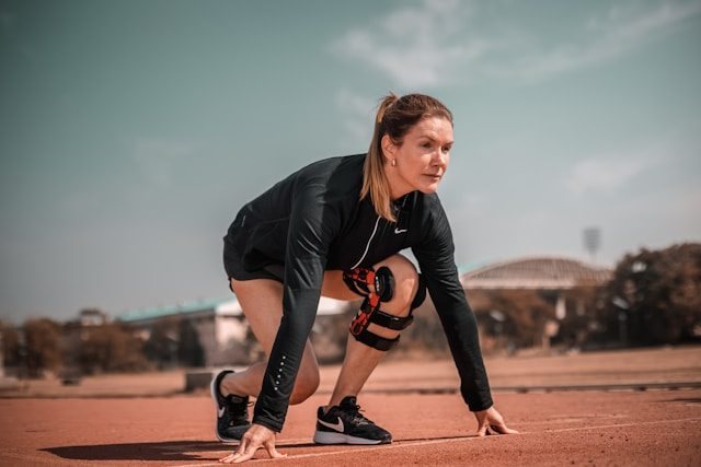 Sportlerin bereitet sich auf den Start eines Laufs vor