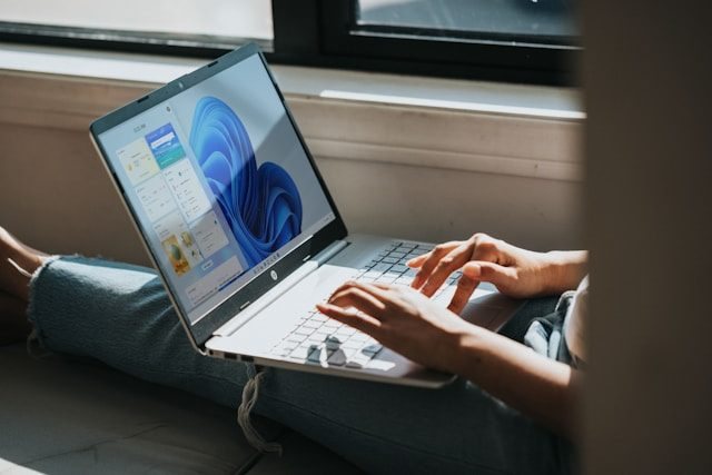 Person tippt an einem Laptop mit Windows-Oberfläche