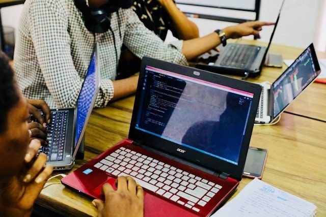 Mehrere Personen arbeiten gemeinsam an Laptops