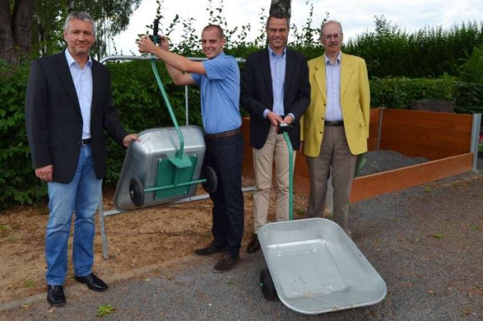 Ingemar Roth, Geschäftsführer der Friedhofsdienst GmbH, Ortsvorsteher Florian Maier, Bürgermeister Dr. Maximilian Ingenthron und Friedhofsverwalter Gerhard Blumer (v.l.n.r.) testen die neuen Transportkarren auf dem Dammheimer Friedhof. Daneben: Die neue Splittbox. (Foto: Stadt Landau in der Pfalz)