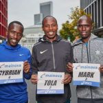 Cybrian Kotut, Tadesse Tola, Mark Korir vor der Festhalle