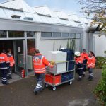 Helfer des Deutschen Roten Kreuzes und des Malteser Hilfsdienstes bringen bei der Katastrophenschutzübung Materialien für die Notfallunterbringung Evakuierter in die Turnhalle der BBS Bingen. (Foto: Kreisverwaltung Mainz-Bingen)