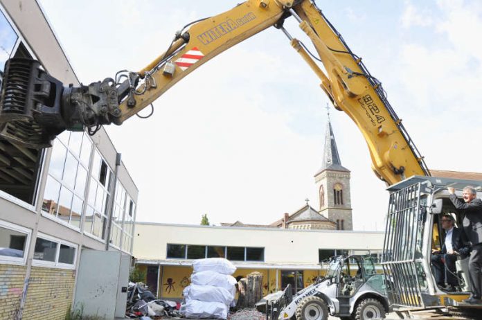 Landrat Christian Engelhardt führt den Bagger zum ersten Schlag, unterstützt von Bürgermeister Helmut Glanzner (Foto: Kreis Bergstraße)