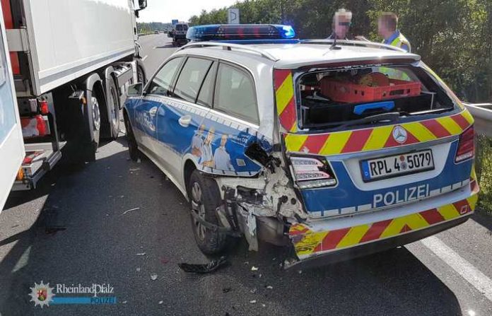 Der Streifenwagen der Autobahnpolizei, der zur Absicherung eines Pannen-Lkw mit eingeschaltetem Blaulicht auf der rechten Fahrspur stand, wurde von dem nachfolgenden Lkw mit voller Wucht hinten links erwischt.