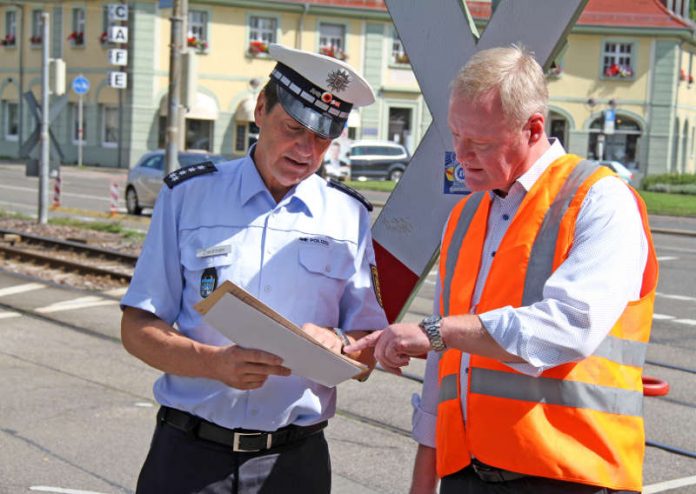 Joachim Zwirner (l.), Leiter des Referats Verkehr beim Polizeipräsidium Karlsruhe, und Wilfried Müller, Eisenbahnbetriebsleiter der Albtal-Verkehrs-Gesellschaft (AVG) möchten die Verkehrsteilnehmer für ein korrektes Verhalten an den Bahnübergängen in Rüppurr und Dammerstock – wie hier am Ostendorfplatz – sensibilisieren (Fotos: AVG)