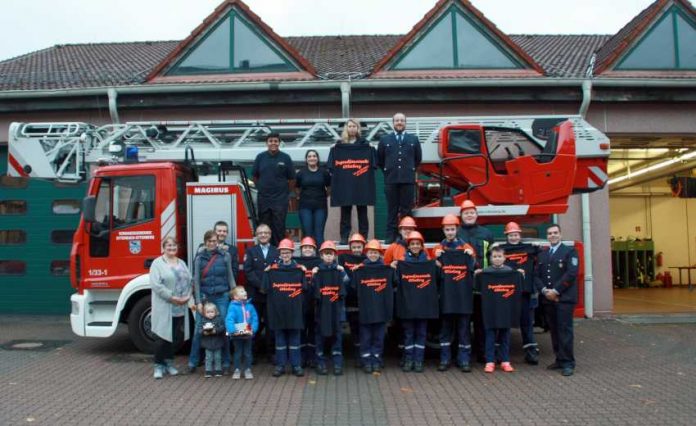 Ellen Fahrbach und Rebekka Wegemann, Patrick Klehr und Dominik Tröster. Thomas Kennel (rechts) sowie die Jugendlichen und Betreuer der Jugendfeuerwehr Otterberg mit den neuen T-Shirts.