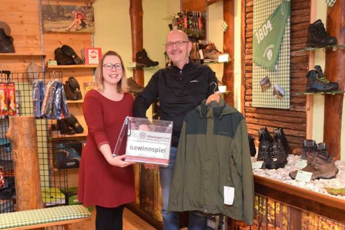 In den Räumen des Wander- und Outdoor-Fachgeschäfts „“ in Michelstadt zogen Mareike Müller, Leiterin der WFB-Tourismusagentur, und Jürgen Schreieck, Mitarbeiter bei „Odenwald Outdoor“, den Gewinner der Nibelungensteig-Wanderpass-Verlosung 2018. Foto: WfB