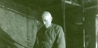 Hammerschmied Daniel Haag beim Schärfen eines Werkzeugs am großen Schleifstein um 1928 (Bild: Archiv Wappenschmiede)