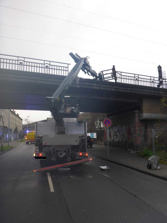 LKW bleibt mit Ladekran an Bahnüberführung hängen