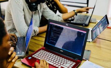 Person mit schwarzem und rotem Acer-Laptop auf dem Tisch (Unsplash / Desola Lanre-Ologun)