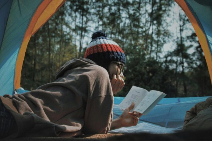 Frau liest Buch im Zelt (Lê Tân / Unsplash)